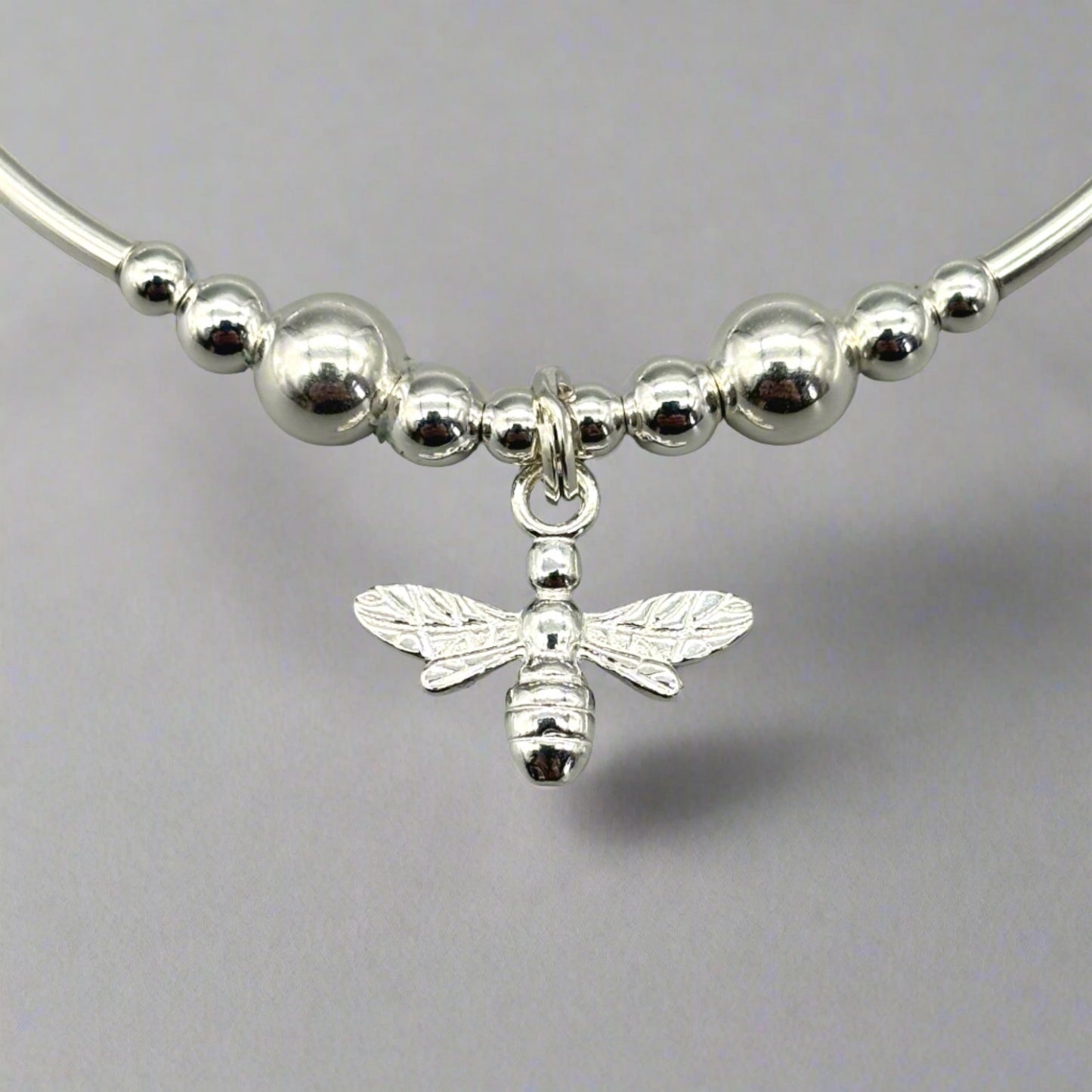 Closeup of bee charm sterling silver stacking stretch bracelet for her by My Silver Wish