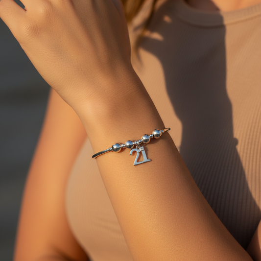 Woman wearing a 21st Birthday charm women's sterling silver stacking bracelet by My Silver Wish
