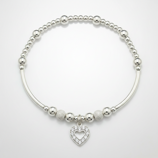 Silver bracelet with heart charm on a white background