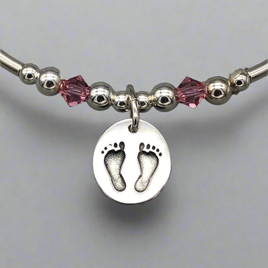 Closeup of Baby girl footprint charm sterling silver hand-made women's stacking bracelet by My Silver Wish