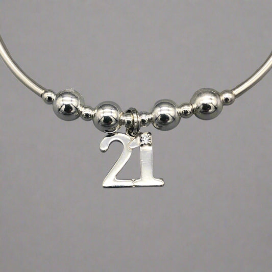Closeup of 21st Birthday charm women's sterling silver stacking bracelet by My Silver Wish