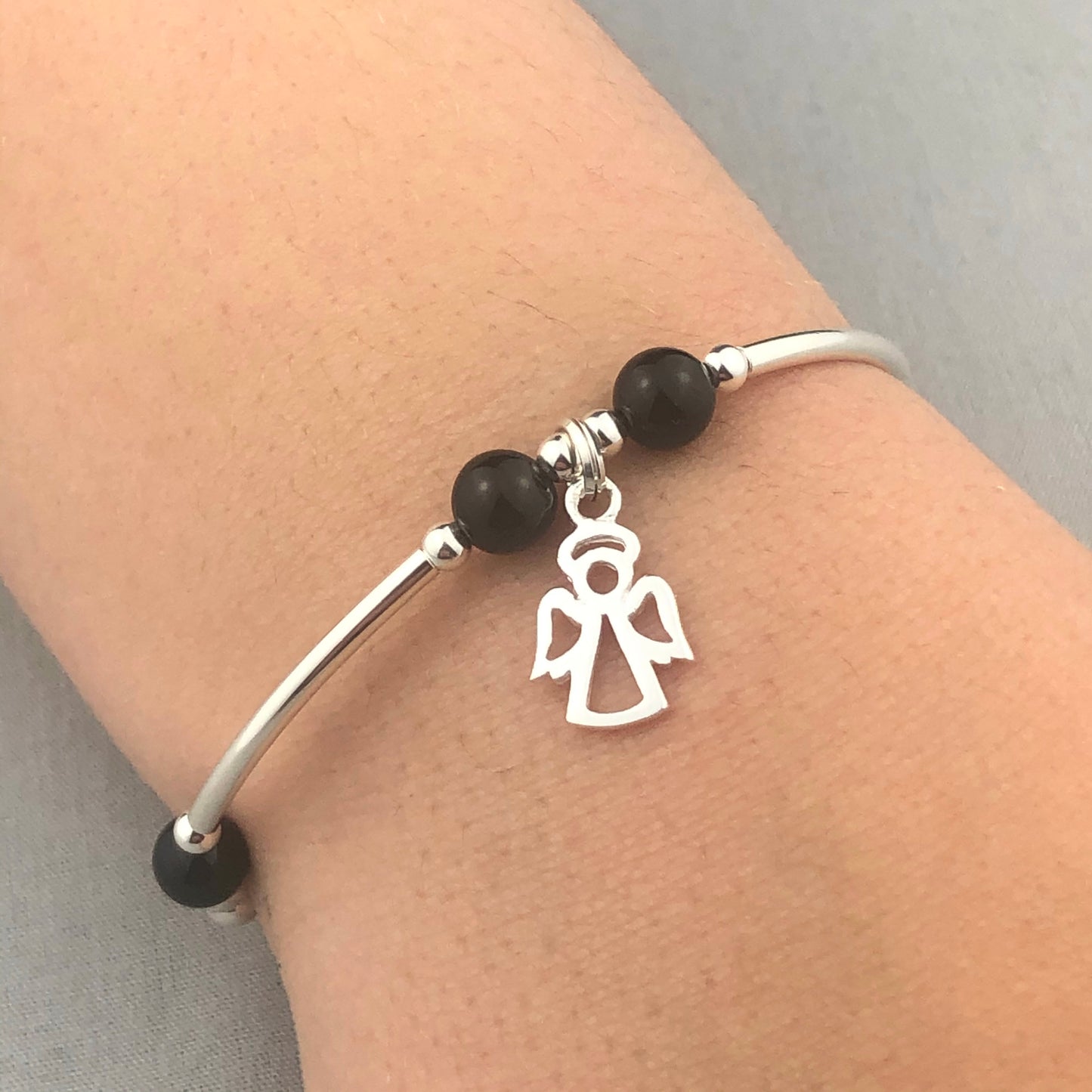 Closeup of Angel charm black onyx gemstone women's sterling silver stacking bracelet by My Silver Wish