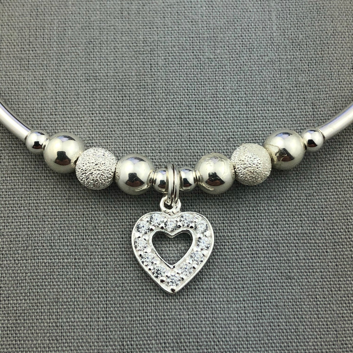 Closeup of Crystal heart charm sterling silver stacking charm bracelet by My Silver Wish
