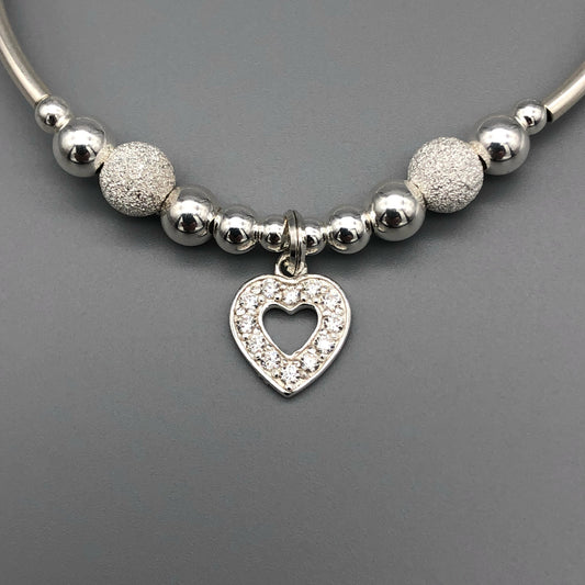 Closeup of Diamond heart charm starburst beads sterling silver hand-made girl's stacking bracelet by My Silver Wish