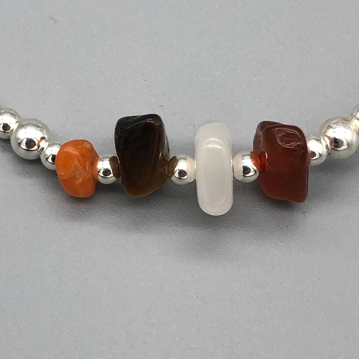 Closeup of confidence healing crystal and sterling silver women's stacking charm bracelet by My Silver Wish