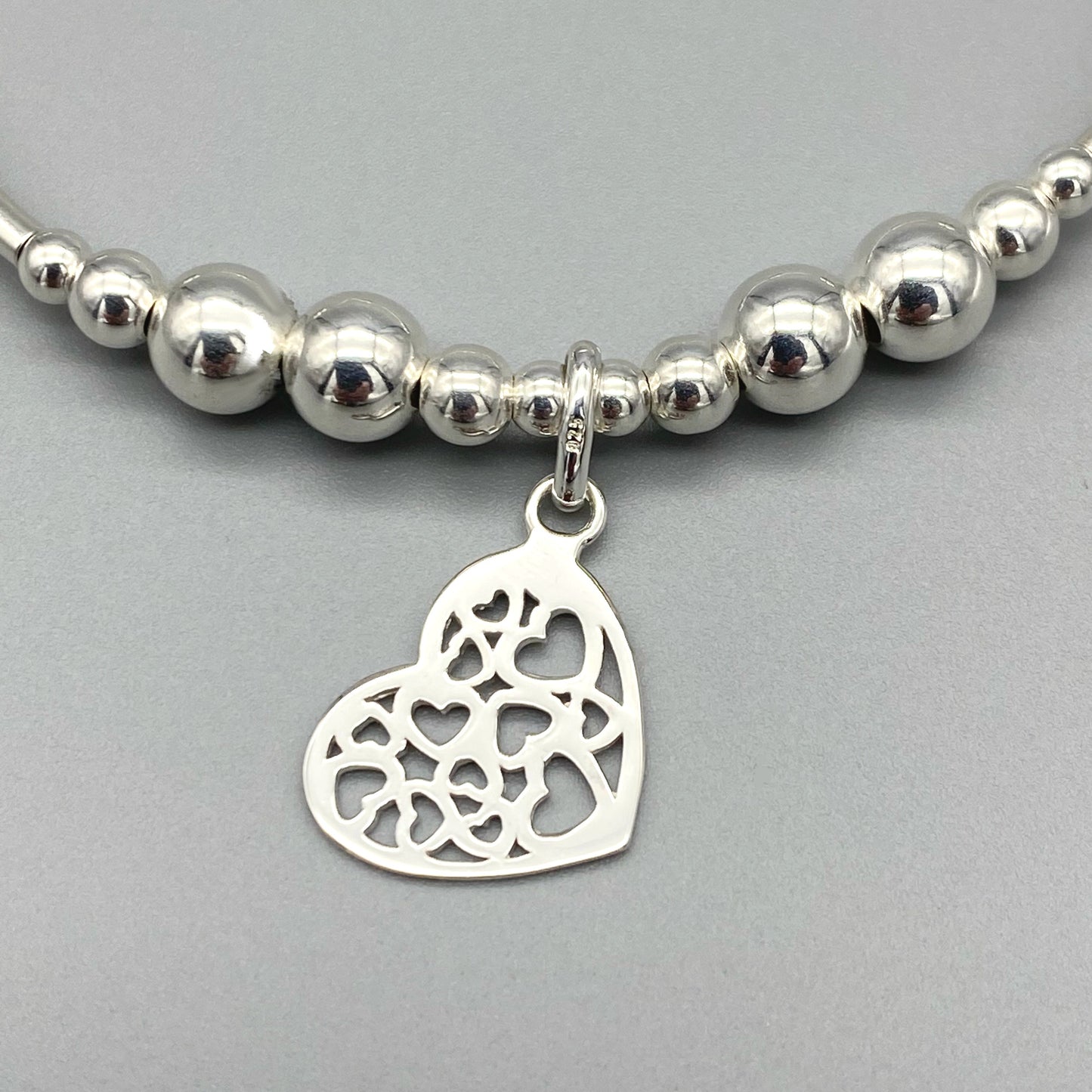 Closeup of Heart charm filigree sterling silver hand-made women's stacking bracelet by My Silver Wish