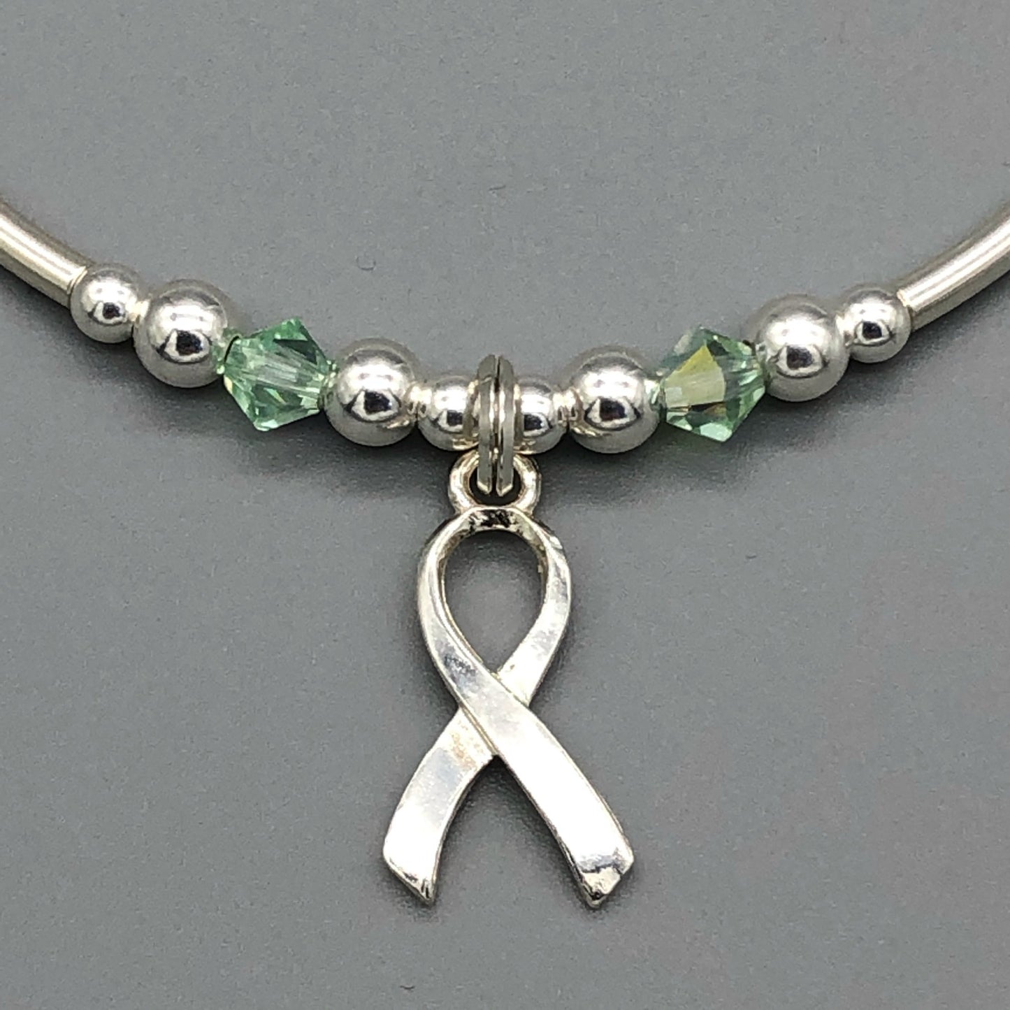 Closeup of Mental Health Awareness ribbon charm sterling silver hand-made women's stacking bracelet by My Silver Wish