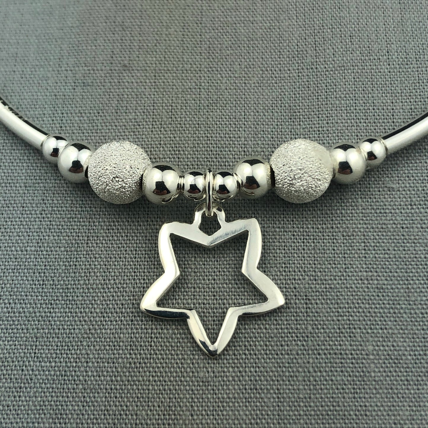 Closeup of Open star charm women's sterling silver stacking charm bracelet by My Silver Wish