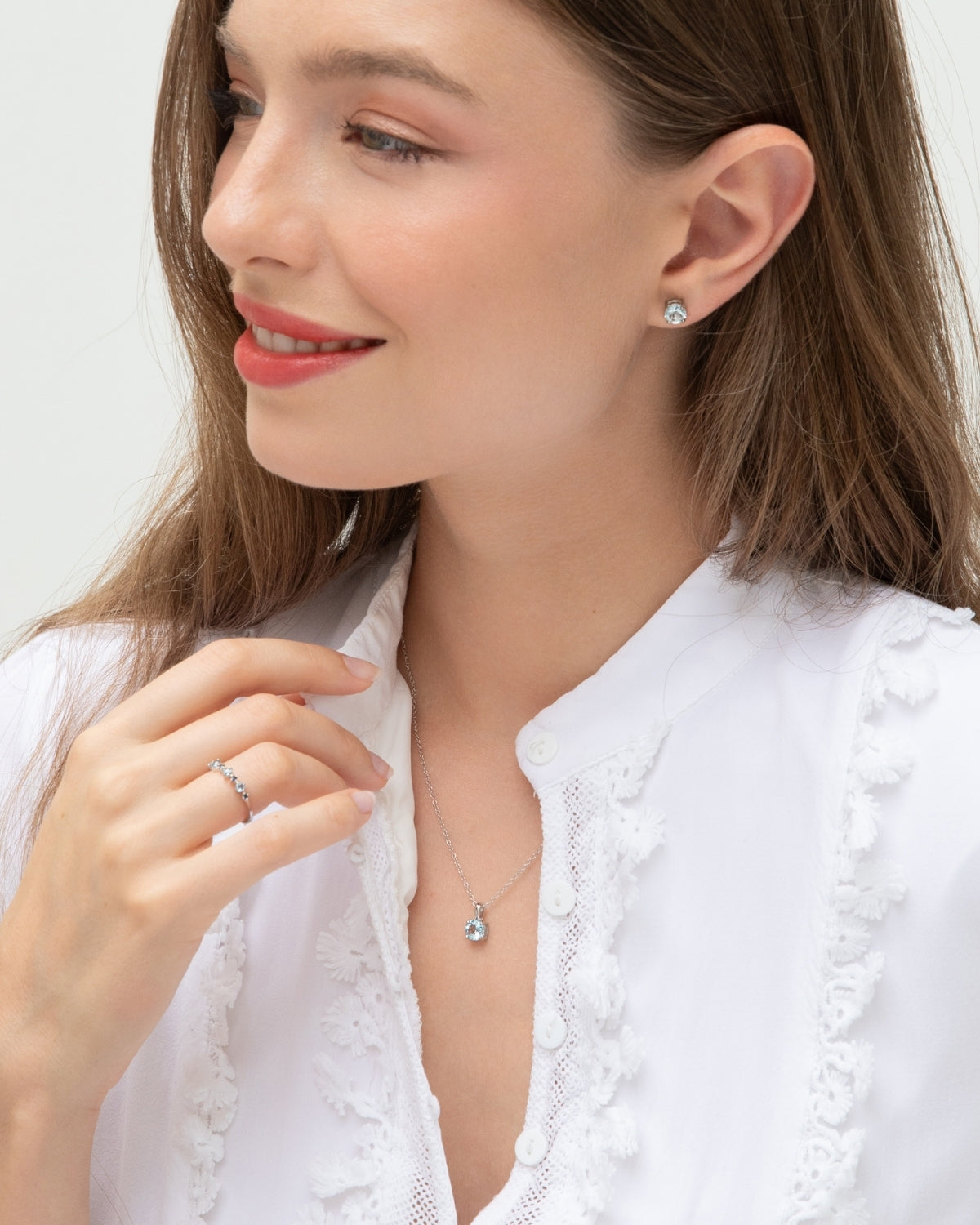 Woman wearing a necklace and earrings on a white background