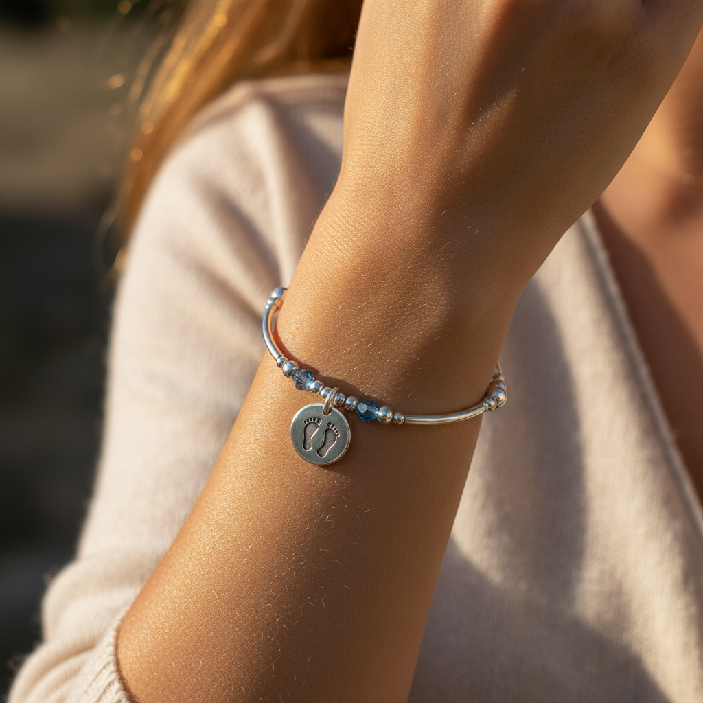Model wearing a Baby boy footprint charm sterling silver hand-made women's stacking bracelet by My Silver Wish