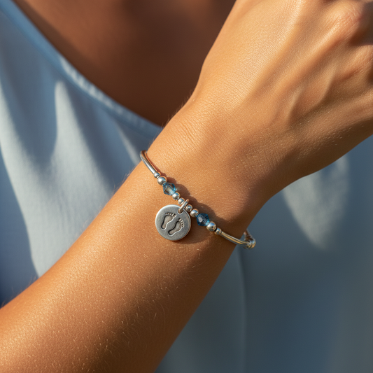 Model wearing a Baby boy footprint charm sterling silver hand-made women's stacking bracelet by My Silver Wish