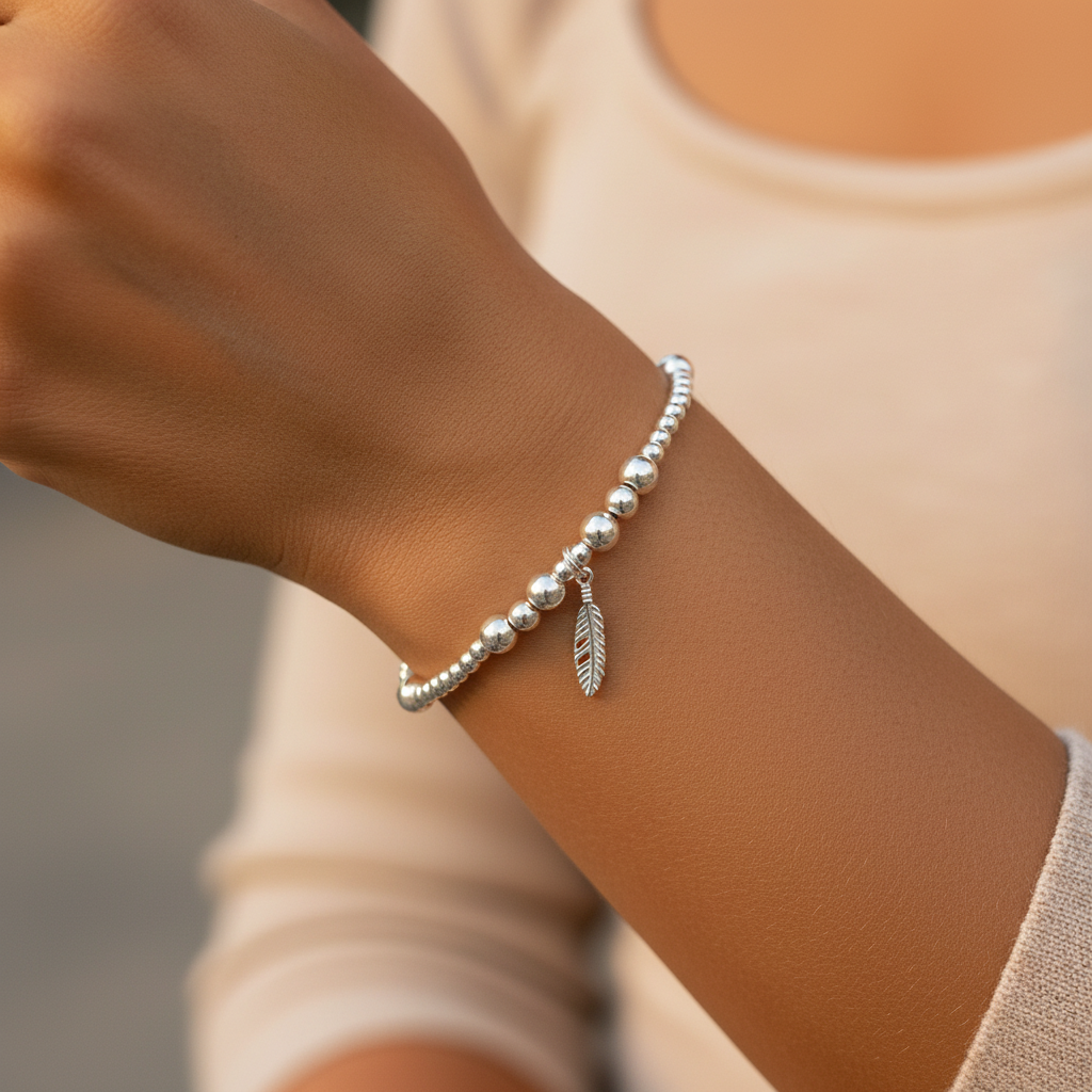 Model wearing a Feather charm women's 925 sterling silver stacking bracelet by My Silver Wish