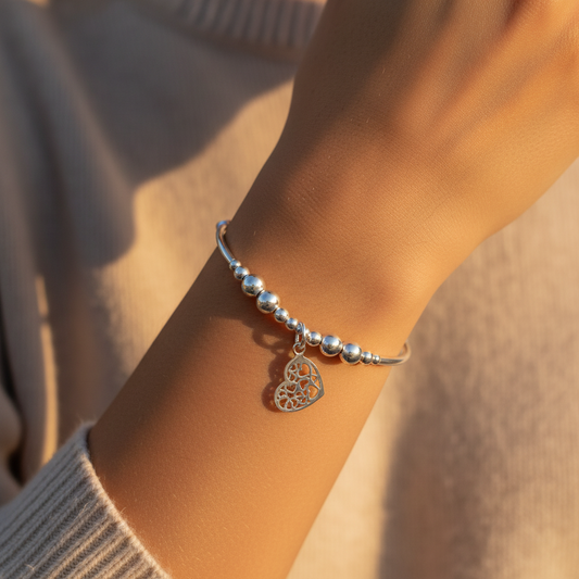 Woman wearing a Heart charm filigree sterling silver hand-made women's stacking bracelet by My Silver Wish