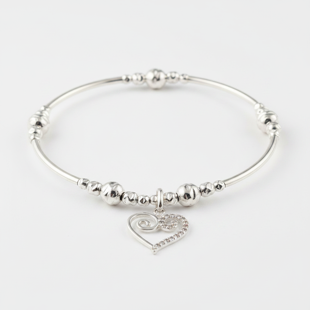 Silver bracelet with swirl heart charm on a white background