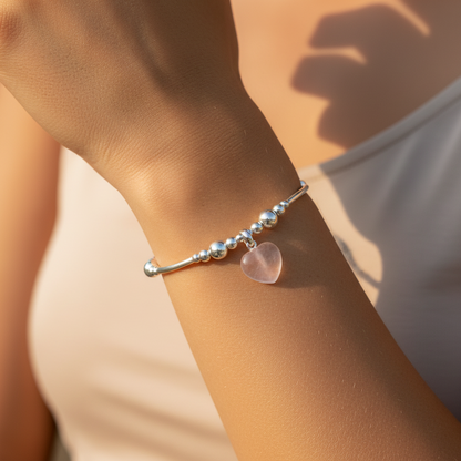 Model wearing a Rose quartz solid heart charm sterling silver hand-made women's stacking bracelet by My Silver Wish