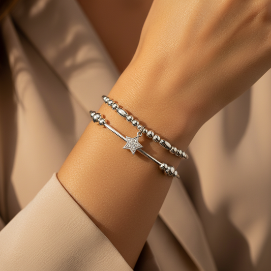 Model wearing a star charm bracelet and stack filler bracelet in sterling silver women's stacking bracelet gift set by My Silver Wish