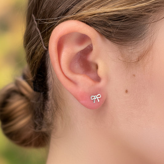 Closeup of ribbon bow sterling silver stud earrings by My Silver Wish