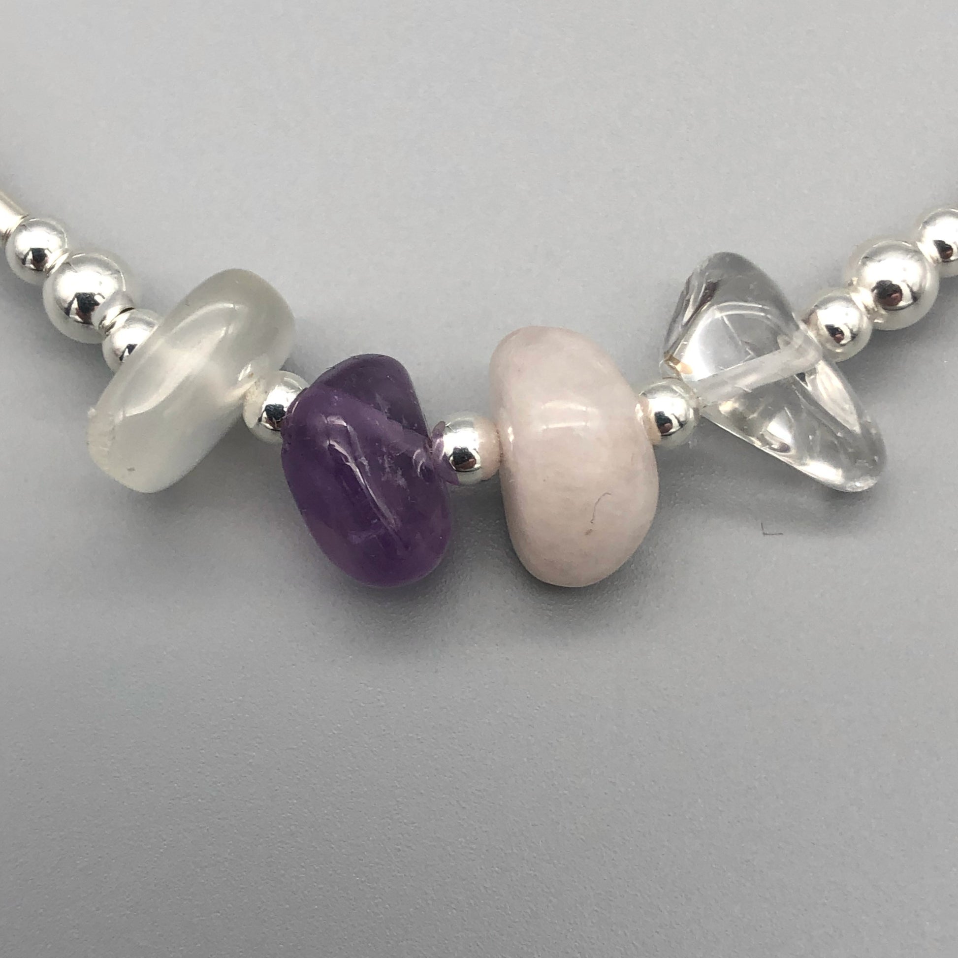 Closeup of Aquarius zodiac star sign women's sterling silver charm stacking bracelet by My Silver Wish